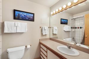 a bathroom with a sink and a toilet and a mirror at Gold Point Resort by Vacatia in Breckenridge