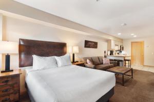 a bedroom with a large bed and a living room at Gold Point Resort by Vacatia in Breckenridge