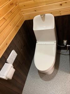 a bathroom with a white toilet in a room at くじゅう花公園　キャンピングリゾート花と星 in Kuju