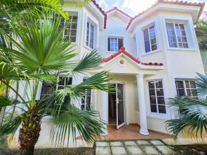 una casa blanca con palmeras delante en Blue Heaven Guest House Bávaro, Punta Cana, Ideal For Couples, en Punta Cana