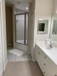 a white bathroom with a shower and a sink at Windemere on Marco Island. 4 BR waterfront home in Marco Island