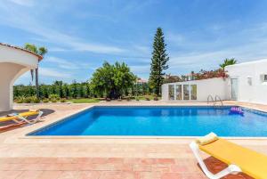 a swimming pool in a villa with a yard at Casa Janus in Carvoeiro