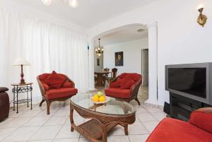 プエルト・デル・カルメンにあるCasa Marquesaのリビングルーム(赤い椅子、テレビ付)