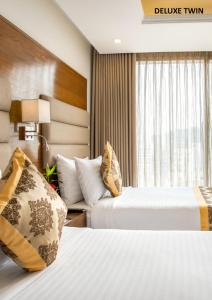 ein Hotelzimmer mit 2 Betten und einem Fenster in der Unterkunft Marino Royal Hotel in Dhaka
