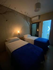 a hotel room with two beds and a window at La em casa Noronha in Fernando de Noronha