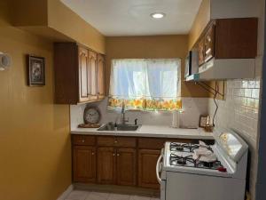 a small kitchen with a stove and a sink at Your cozy comfy rental in Cedar Manor