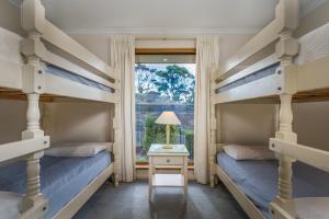 a bedroom with two bunk beds and a window at Baudin House in Penneshaw