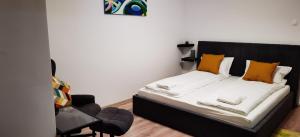 a bedroom with a bed with yellow pillows and a chair at Focus Lux in Miercurea-Ciuc