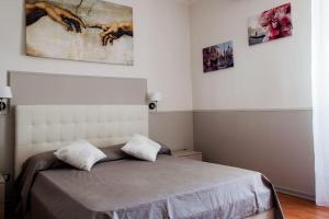 um quarto com uma cama e pinturas na parede em Appartampeppe em Acireale