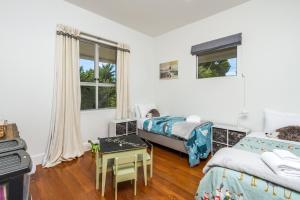 a bedroom with two beds and a table in it at Corokia Villa in Richmond