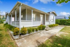 a white house with a yard in front of it at Corokia Villa - Peaceful, Modern Villa in Richmond in Richmond