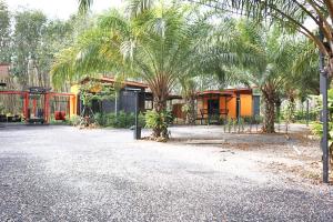 a building with palm trees in front of it at บ้านต้นตาล ไอ้ไข่เด็กวัดเจดีย์ รีสอร์ต in Ban Theppharat (1)