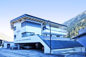 a building with a car parked in a parking lot at A4 AlmA Alpin Appartments in Ischgl