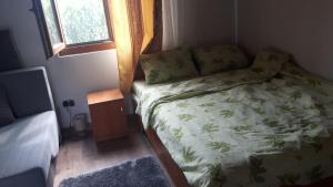 a small bedroom with a bed and a window at Pensiunea Tarina in Şuncuiuş