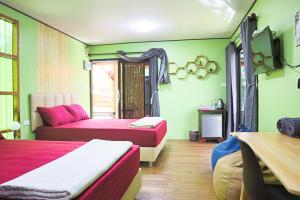 Zimmer mit 2 Betten und einem Sofa in der Unterkunft บ้านต้นตาล ไอ้ไข่เด็กวัดเจดีย์ รีสอร์ต in Ban Theppharat (1)