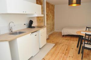 a kitchen with a sink and a table with a bed at Montmartre in Paris