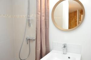 een badkamer met een douche, een wastafel en een spiegel bij Montmartre in Parijs