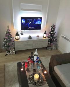 een woonkamer met een tv en twee kerstbomen bij Apartman Dunja in Prijedor
