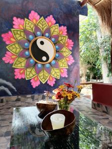 a painting of a flower on a wall with a table at Finca Oz in Homún