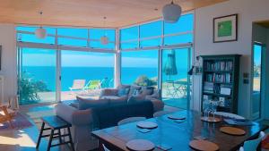 uma sala de estar com um sofá e uma mesa em 180° seaviews, superior coastal cottage em Waitoitoi