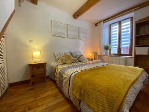 een slaapkamer met een bed met een gele sprei bij Duplex cosy au cœur de Barcelonnette in Barcelonnette