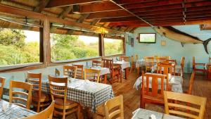 a dining room with tables and chairs and windows at Sodwana Bay Lodge Dive & Fishing Resort in Sodwana Bay