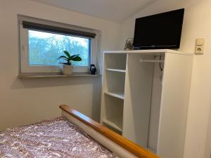 a living room with a tv on a white shelf at Ferienwohnung Eiderblick in Hennstedt