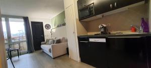 a kitchen with a sink and a living room at Dans la résidence les jardins d opale in Le Touquet-Paris-Plage