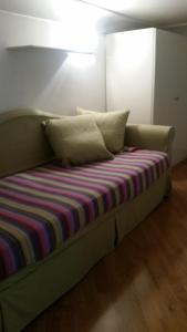 un sofá verde con una manta a rayas y almohadas en Casa Allegra en Nápoles