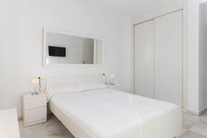 マルベーリャにあるModern Apartment Close to Puerto Banusの白いベッドルーム(大きな白いベッド1台、鏡付)