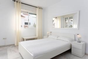 マルベーリャにあるModern Apartment Close to Puerto Banusの白いベッドルーム(大きな白いベッド1台、窓付)