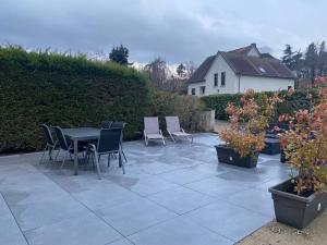 Un patio con mesa y sillas y plantas. en Gite Des 3 Chateaux, en Ribeauvillé