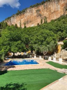una piscina con césped junto a una montaña en Cabanas El Nogueral, en Gontar