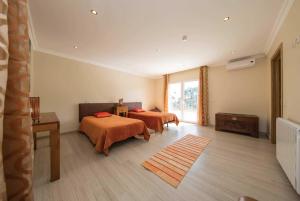 a bedroom with two beds and a window at Casa das Oliveiras - OLIVE TREE in Monchique +34 photos