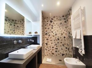 La salle de bains est pourvue de 2 lavabos et d'une douche. dans l'établissement Visconti Suites by FNA Hospitality Roma, à Rome