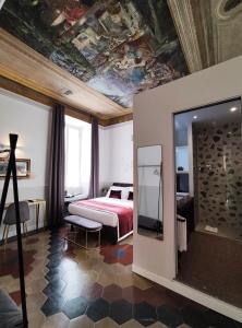 - une chambre avec un lit et un plafond orné d'une peinture dans l'établissement Visconti Suites by FNA Hospitality Roma, à Rome