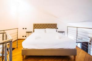 a bedroom with a large bed with white sheets at Hotel Villa Lauri in Neive