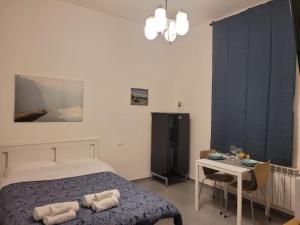 a bedroom with a bed and a desk and a table at Dormi Tranquillo in Bologna