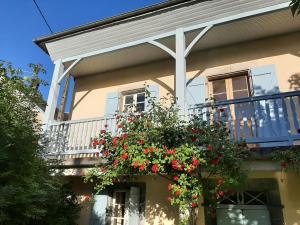 una casa con un balcone con fiori rossi di Gîte d'étape Le Couvent d'Ossau a Louvie Juzon