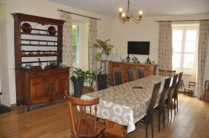 una sala da pranzo con tavolo, sedie e TV di Gîte d'étape Le Couvent d'Ossau a Louvie Juzon
