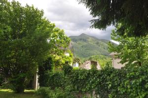una casa con alberi e montagne sullo sfondo di Gîte d'étape Le Couvent d'Ossau a Louvie Juzon Altre 29 foto