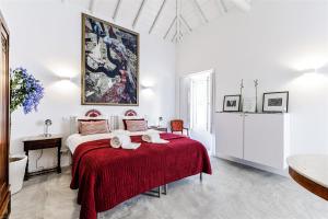 a white bedroom with a bed with a red blanket at Alma da Vida Ferragudo in Ferragudo