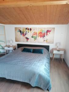a bedroom with a bed and three paintings on the wall at Chambre familiale "le pêcher" in Saillans