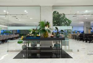 una sala da pranzo con tavolo e fiori di Hotel Carlos I Silgar a Sanxenxo