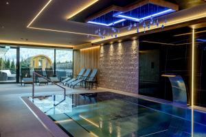 een zwembad in een huis met blauwe lichten bij Hotel La Perla in Andalo