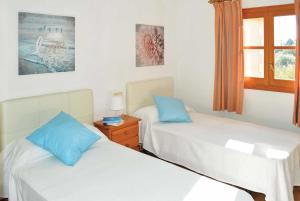 ポリェンサにあるCa'n Vobisの青い枕付きのベッド2台が備わる客室です。
