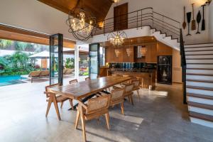 una cucina e una sala da pranzo con tavolo e sedie in legno di Villa Nusantara 6 by Alfred in Bali a Canggu