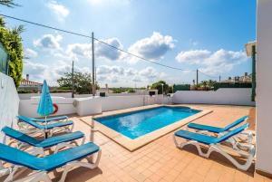 a swimming pool with two lounge chairs next to a swimming pool at Villa Patri in Cala en Porter