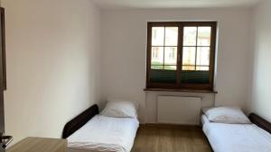 dwa łóżka w pokoju z oknem w obiekcie Apartament Portowe Wspomnienia w Ustce