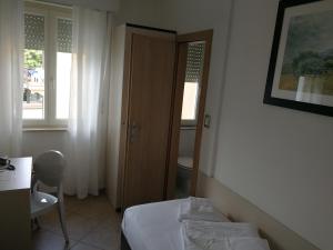 a bedroom with a bed and a door and a table at Hotel Sirena in Malcesine